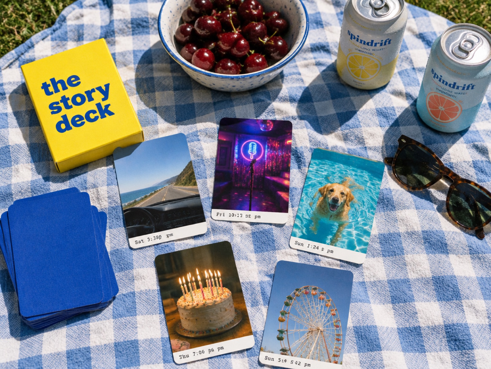 A deck of photo cards and a yellow box on a picnic blanket