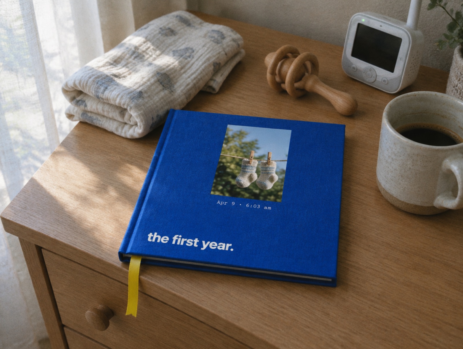 A cobalt hardcover titled the first year on a nursery dresser