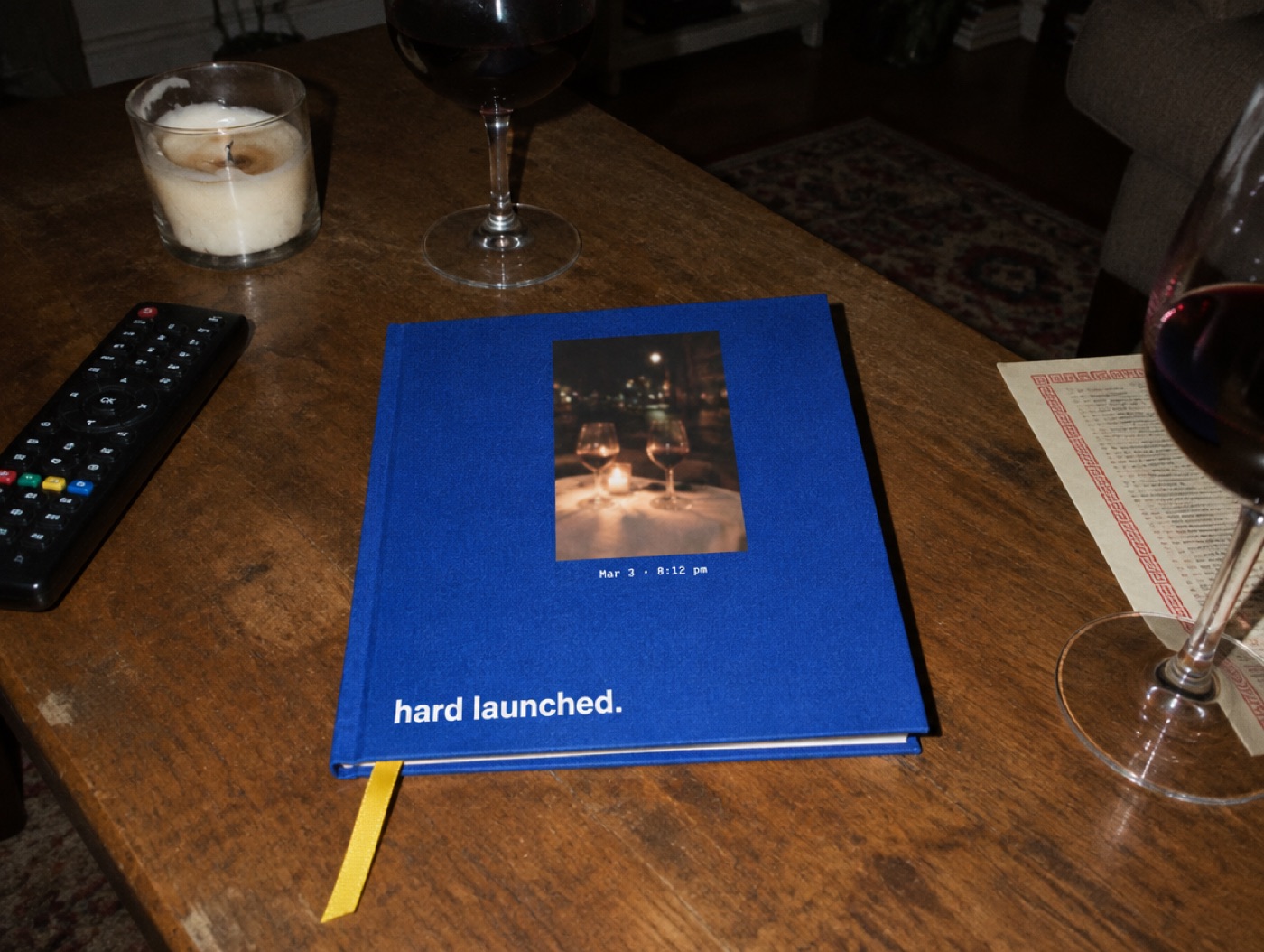 A cobalt hardcover titled hard launched on a coffee table at night